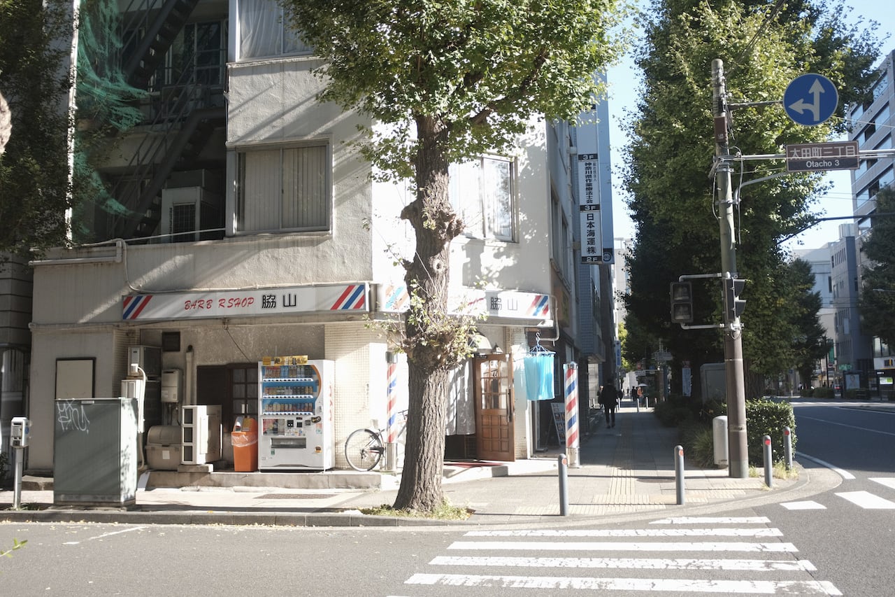 a street corner in japan with a barber shop